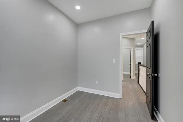 a view of a room with wooden floor and a small space