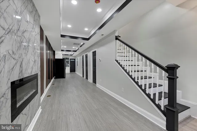 a view of staircase with lots of frames on wall and wooden floor