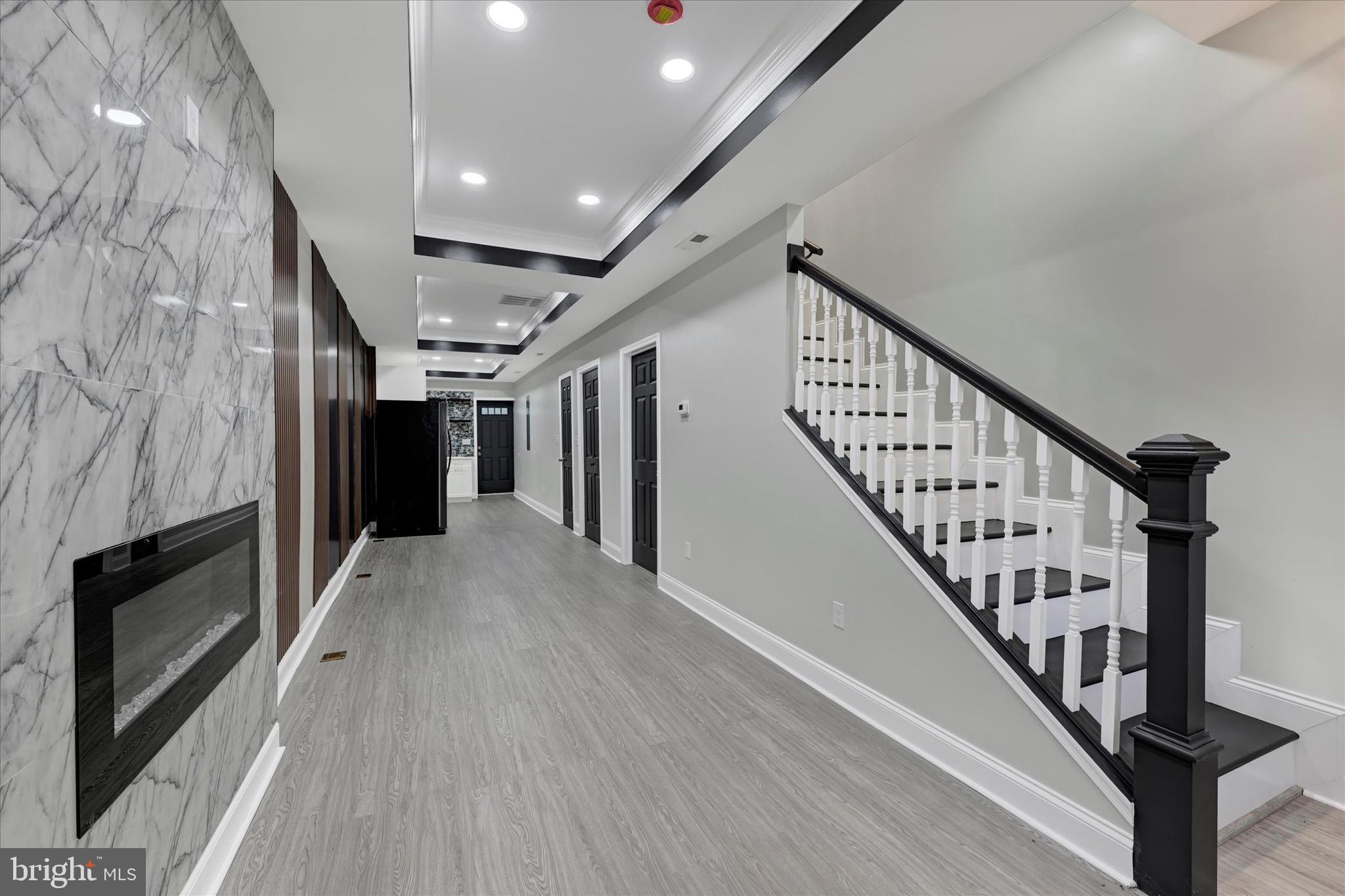 531 Wilson Street Baltimore, MD 21217 - Photo 4 of 24 a view of staircase with lots of frames on wall and wooden floor