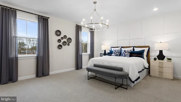 a spacious bedroom with a bed and a chandelier