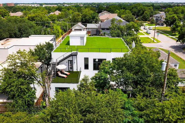an aerial view of a house with a garden and lake view