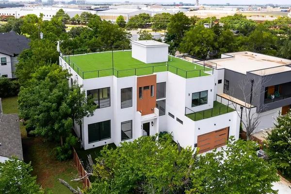 a aerial view of a house with a yard potted plants and large tree