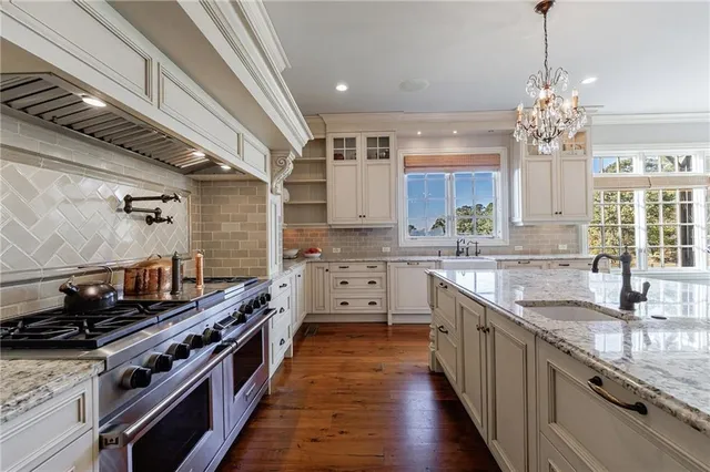 a large kitchen with kitchen island granite countertop a large island in the center and a chandelier
