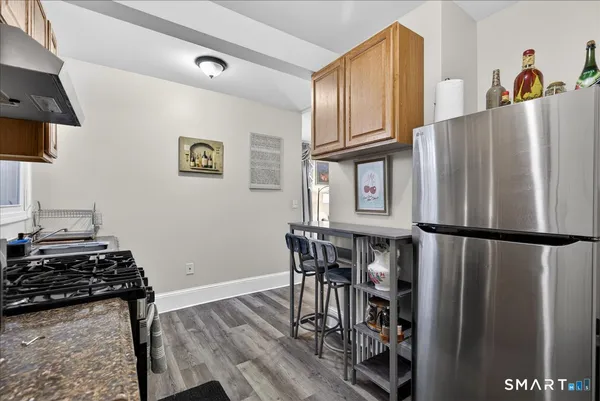 a kitchen with stainless steel appliances granite countertop a refrigerator and a stove top oven