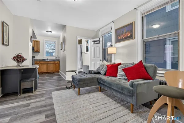 a living room with furniture and a wooden floor