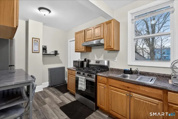 a kitchen with stainless steel appliances granite countertop a stove a sink and a microwave