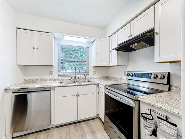 a kitchen with stainless steel appliances granite countertop a sink and a stove
