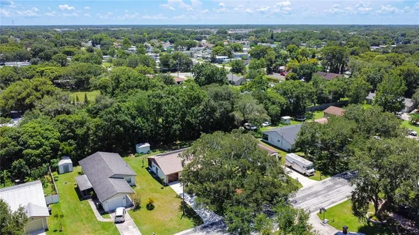 an aerial view of residential houses with outdoor space and trees