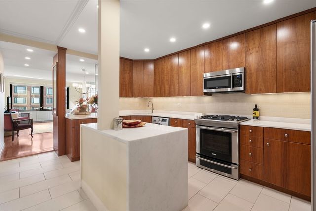 a kitchen with stainless steel appliances a stove a sink a microwave a refrigerator and a microwave