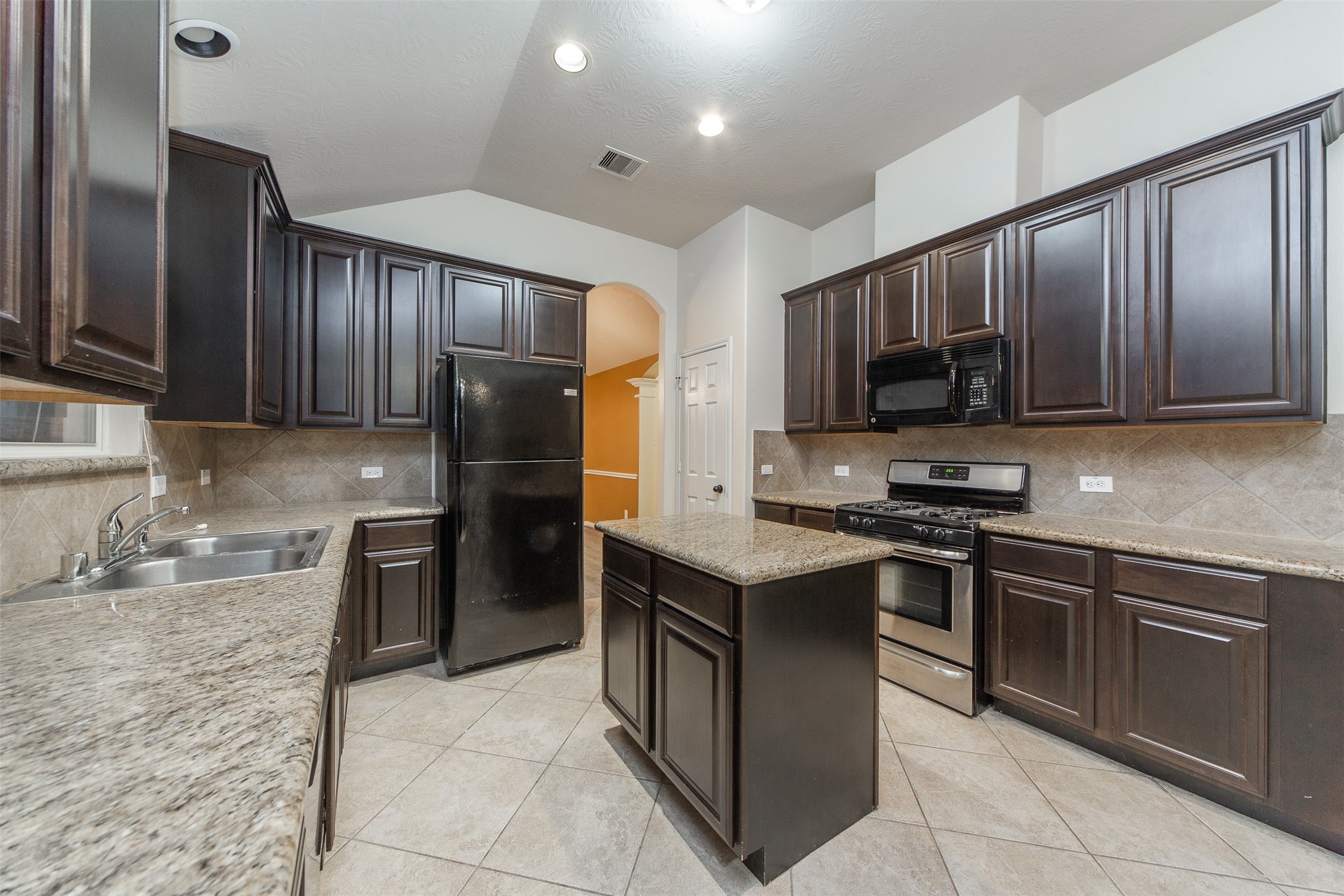 3418 Lily Ranch Drive Katy, TX 77494 - Photo 11 of 24 a kitchen with stainless steel appliances granite countertop wooden cabinets a stove top oven a sink and dishwasher