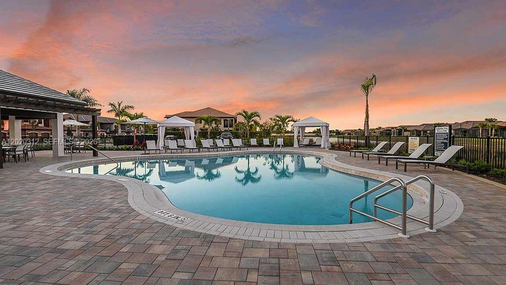15323 Lucerna Street, Unit 204 Naples, FL 34114 - Photo 16 of 29 a view of a swimming pool with a table and chairs