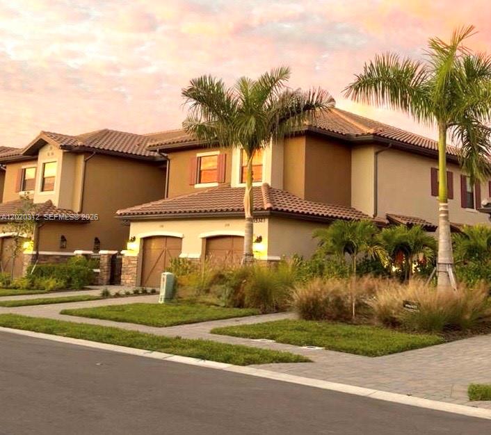 15323 Lucerna Street, Unit 204 Naples, FL 34114 - Photo 29 of 29 a front view of a house with a garden