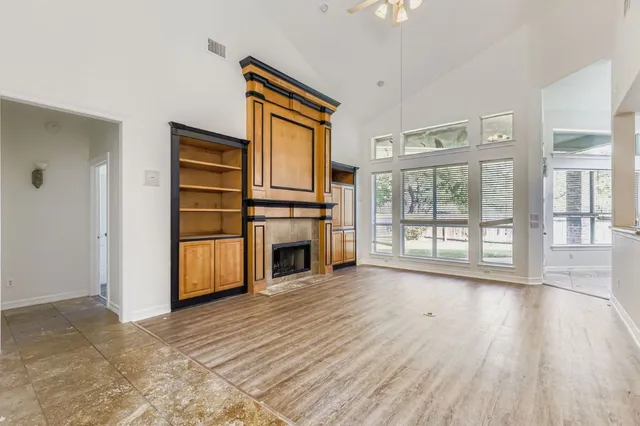a view of a kitchen with wooden floor electronic appliances and windows