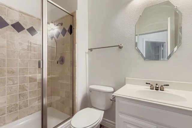 an empty room with windows and chandelier fan
