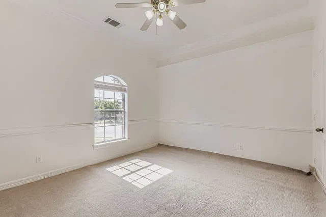 an empty room with a window and a fan