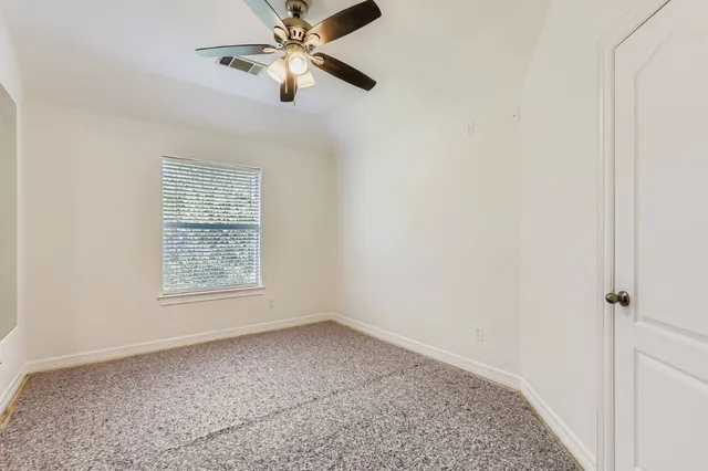 an empty room with a chandelier fan and closet