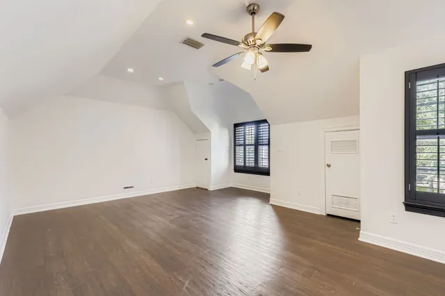 a view of a kitchen with a stove cabinets a ceiling fan and wooden floor