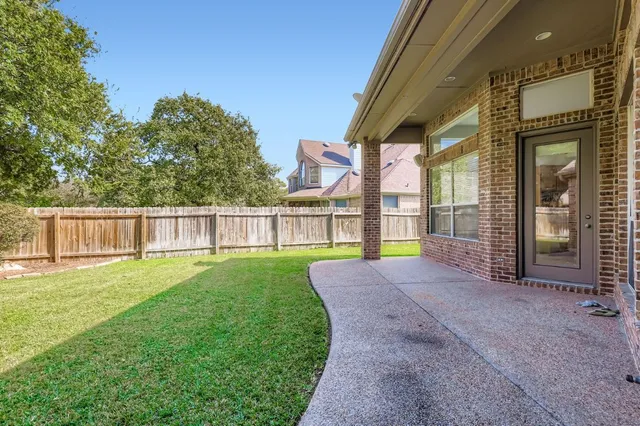 a view of a house with a backyard and a patio