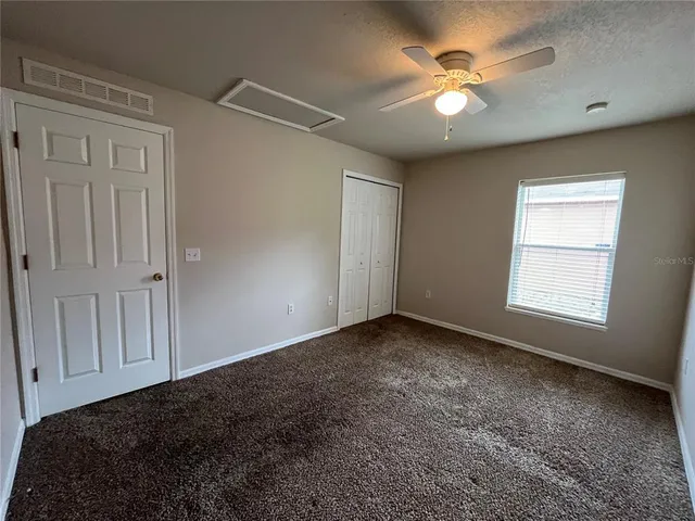 a view of a livingroom with a ceiling fan and window