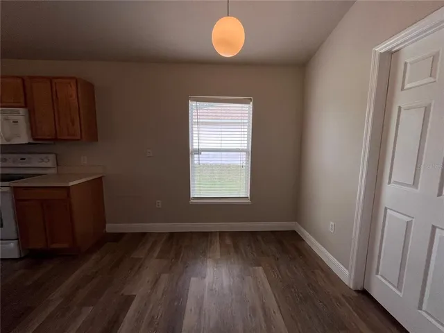 a view of a room with wooden floor and window