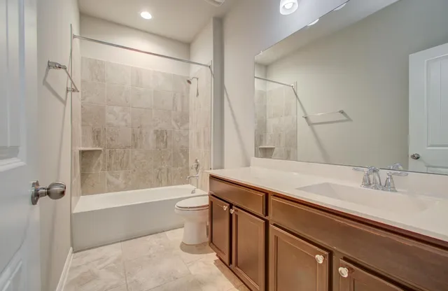 a bathroom with a sink a toilet a mirror and shower