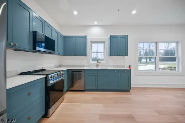 a kitchen with stainless steel appliances granite countertop a stove a sink and a microwave