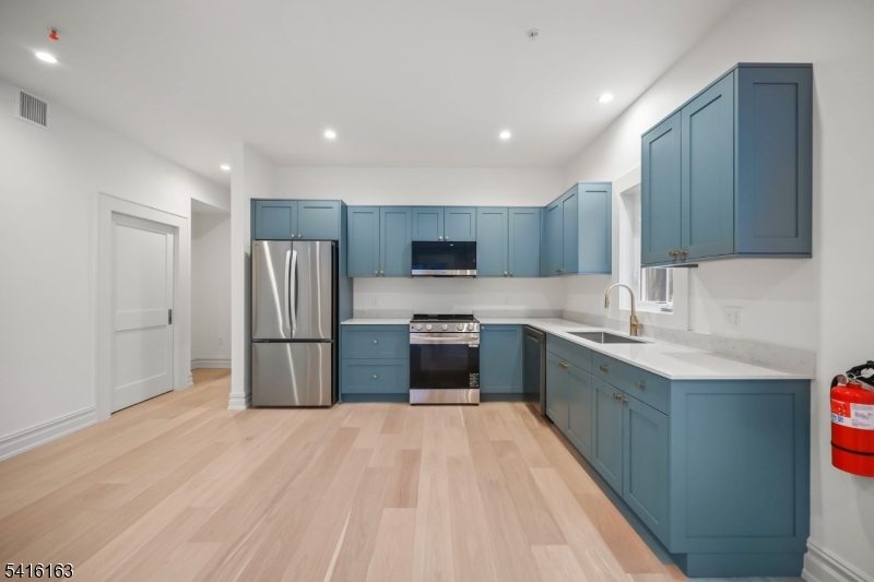 1209 Littleton Road, Unit B Morris Plains, NJ 07950 - Photo 8 of 19 a kitchen with stainless steel appliances granite countertop a refrigerator sink and wooden cabinets