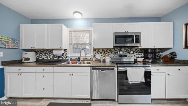 a kitchen with granite countertop a sink and cabinets