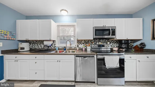 a kitchen with granite countertop a sink and cabinets