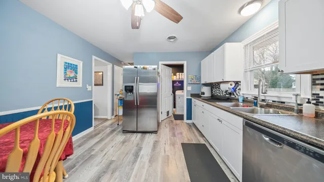 a kitchen with stainless steel appliances granite countertop a refrigerator a stove a sink dishwasher and cabinets with wooden floor