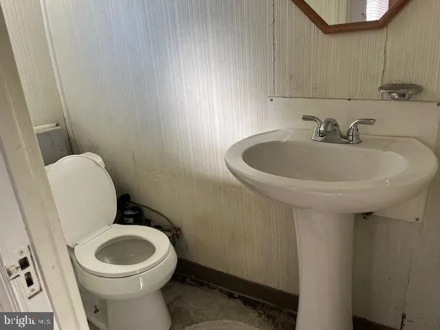 a white toilet sitting next to a white sink