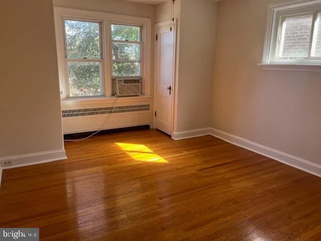 an empty room with a window and wooden floor