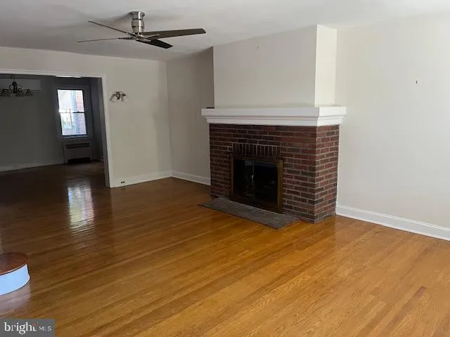 a view of empty room with wooden floor and fireplace