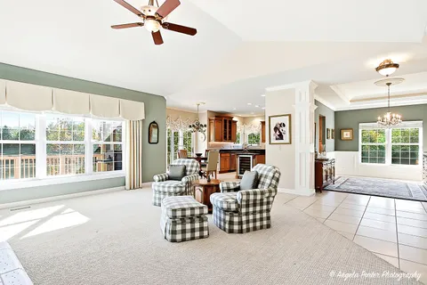 a living room with furniture floor to ceiling window and book shelf