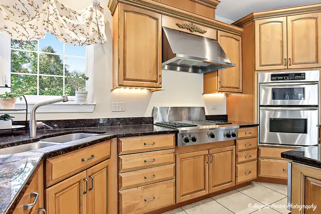 a kitchen with stainless steel appliances granite countertop a stove and a sink