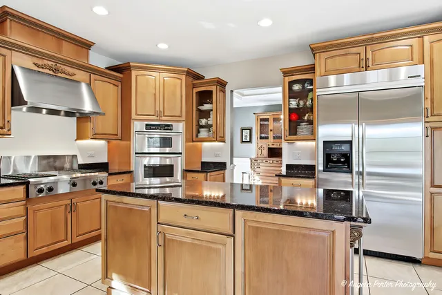 a kitchen with stainless steel appliances granite countertop a refrigerator and a sink