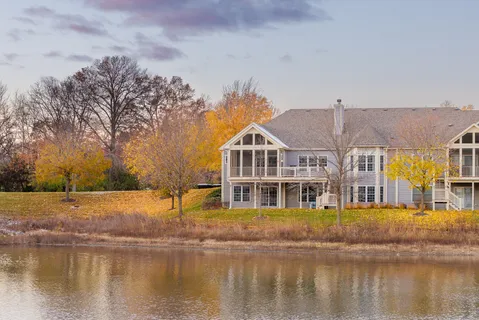 a front view of a building with lake view and trees around
