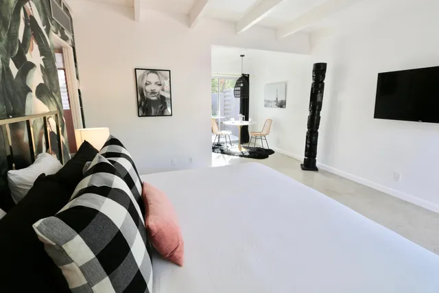 a bedroom with a bed and a flat tv screen on the dresser