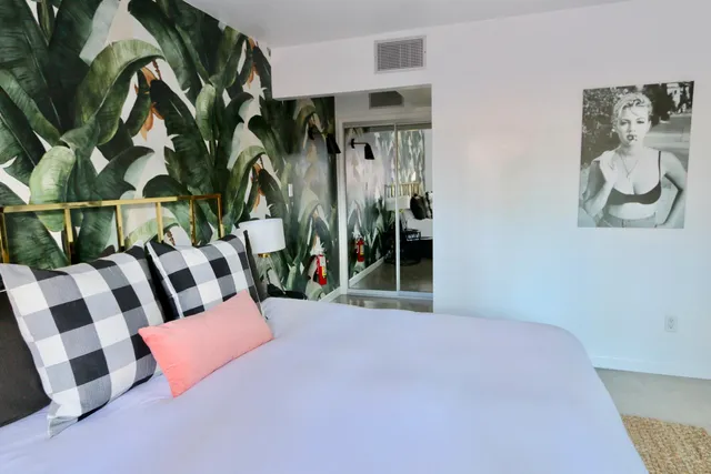 a bedroom with a bed and a painting on the wall