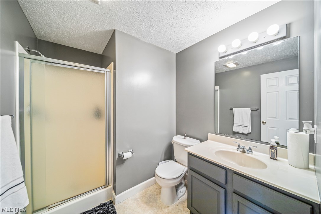 7290 Turner Road Pierpont, OH 44082 - Photo 22 of 36 Bathroom with vanity, toilet, tile flooring, and a textured ceiling