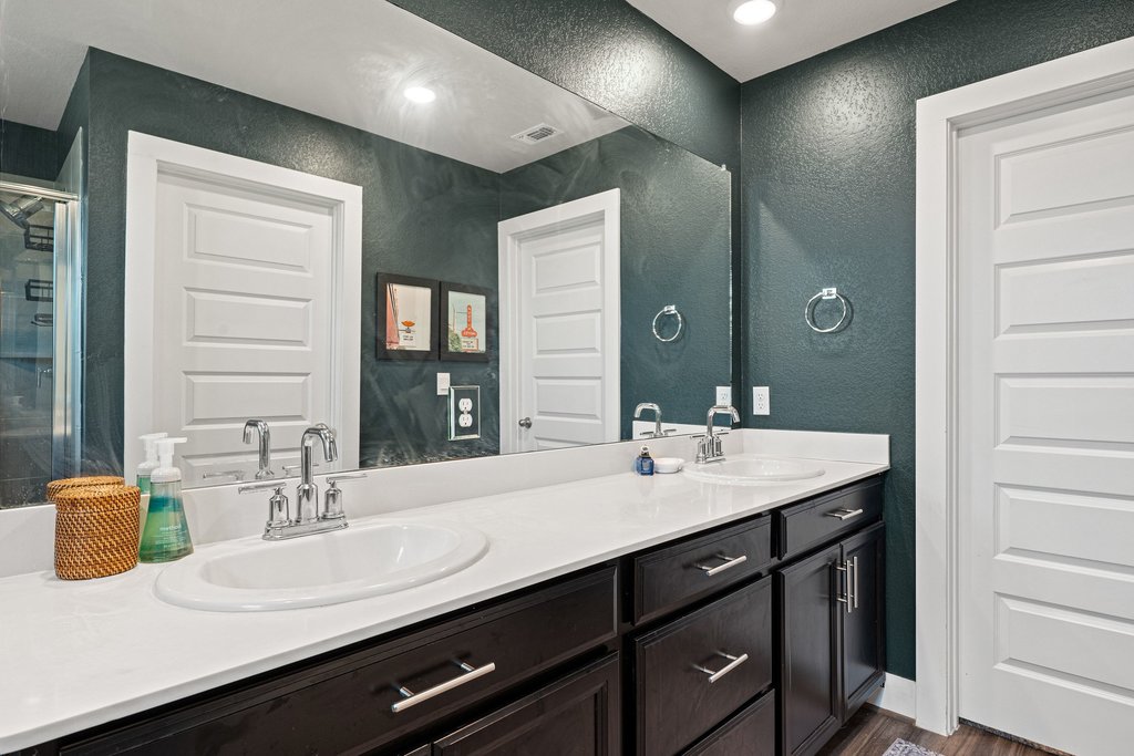 7403 Travertine Spring Drive, Unit 117 Austin, TX 78744 - Photo 22 of 37 Dual vanities with abundant counter space complement this well-appointed bathroom.
