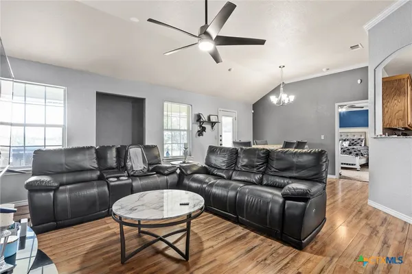 a living room with furniture a ceiling fan and a wooden floor