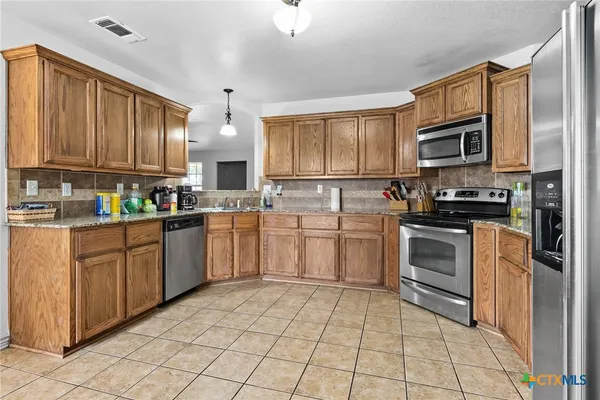 a kitchen with granite countertop a stove sink and cabinets
