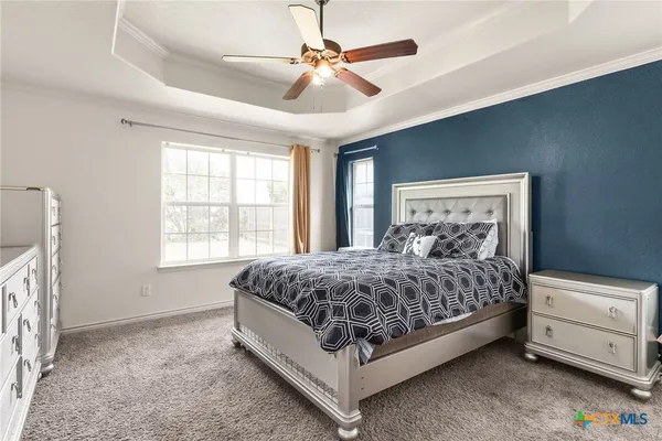 a spacious bedroom with a bed and a chandelier