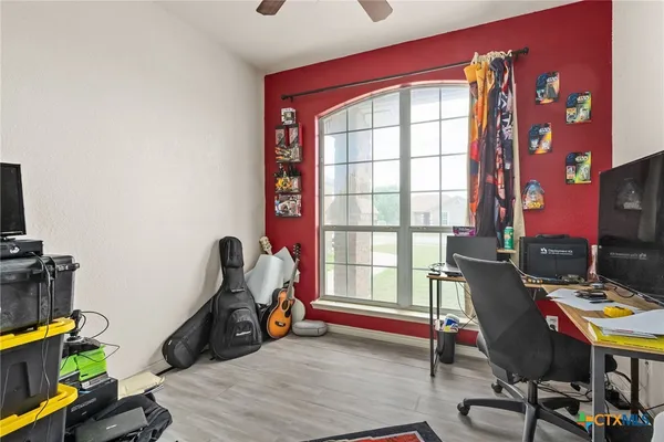 a view of a workspace with furniture and a window