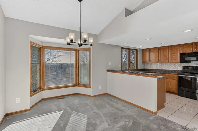 a kitchen with granite countertop a sink stove and microwave