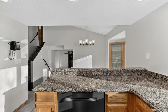a kitchen with stainless steel appliances granite countertop a sink window and cabinets