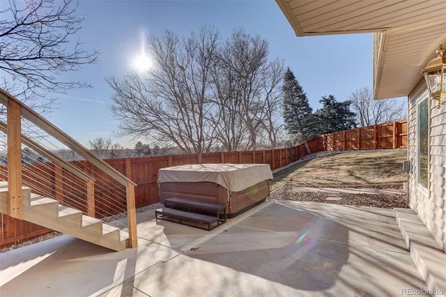 a view of backyard with wooden fence and large trees