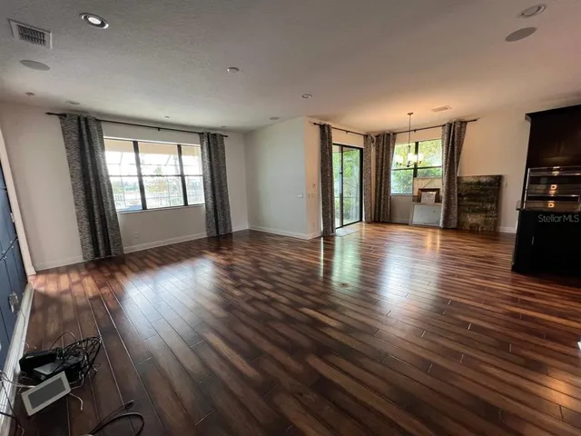 an empty room with piano table and windows