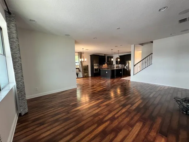 a view of a living room hardwood floor and a kitchen